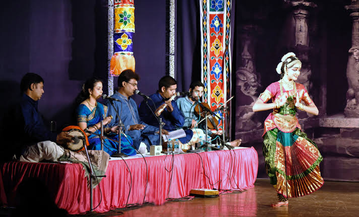 Group musicians and classical dancer performing on stage
